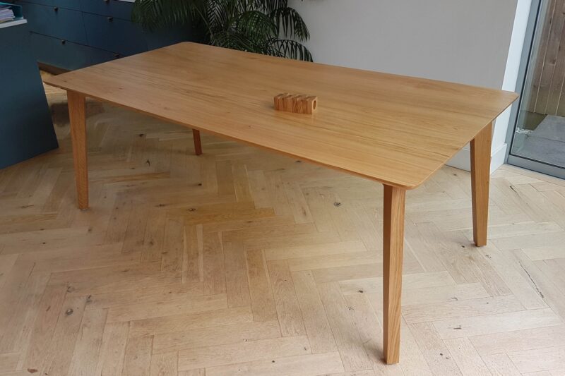 Mid-century modern style oak dining table with splayed and tapered legs